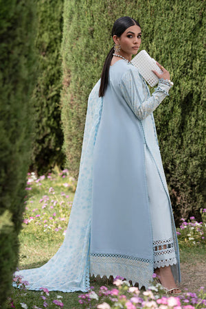 Woman in a light blue traditional outfit with a matching dupatta, standing outdoors with greenery and flowers in the background.
Aveline_By_Ruuposh_Collection_3
