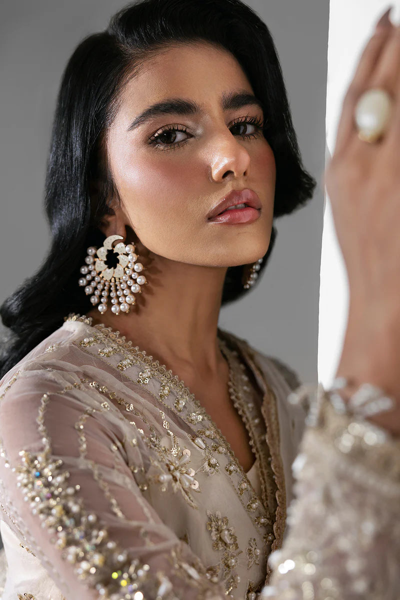 Woman wearing a traditional outfit with intricate jewelry and embroidery.
