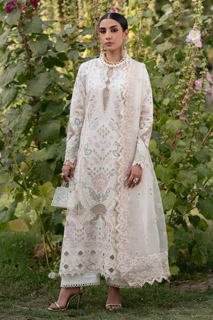 Woman in a white embroidered outfit standing in a garden with greenery and flowers.
Elaris_By_Ruuposh_Collection_6
