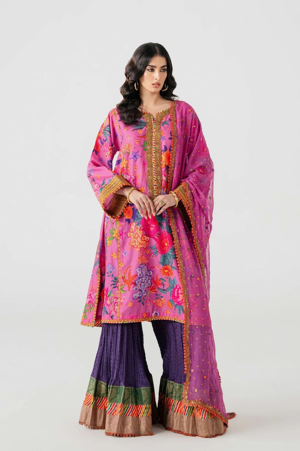 Woman wearing a colorful traditional outfit with a pink top and purple pants on a white background.
Ihasa Bai By Ruuposh Collection 02