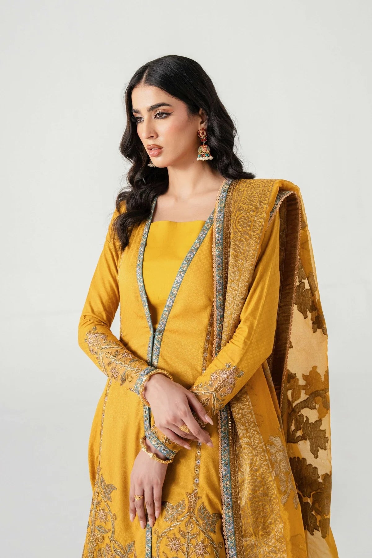 Woman wearing a mustard yellow traditional outfit with intricate designs on a white background.
Kunj Buta By Ruuposh Collection 04