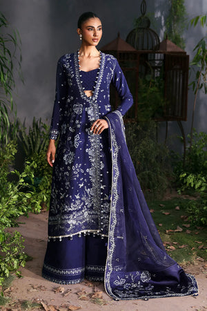 Woman wearing a traditional blue embroidered outfit with a matching dupatta in an outdoor setting. MAISON