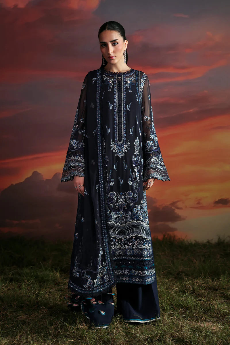 Woman in a dark blue embroidered dress standing against a dramatic sunset sky.
Muse_By_Ruuposh_Collection_01