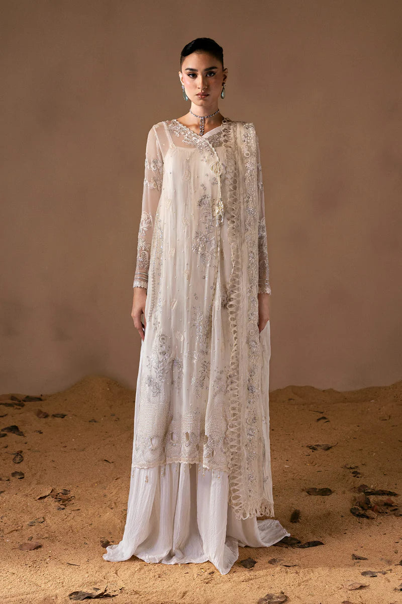 Woman wearing a long, light-colored embroidered dress standing in a desert setting.
Mystique_By_Ruuposh_Collection_01