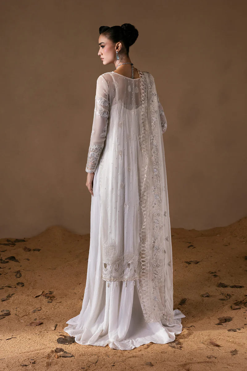 Woman in a white embroidered dress standing on sandy ground with a neutral background.
Mystique_By_Ruuposh_Collection_04