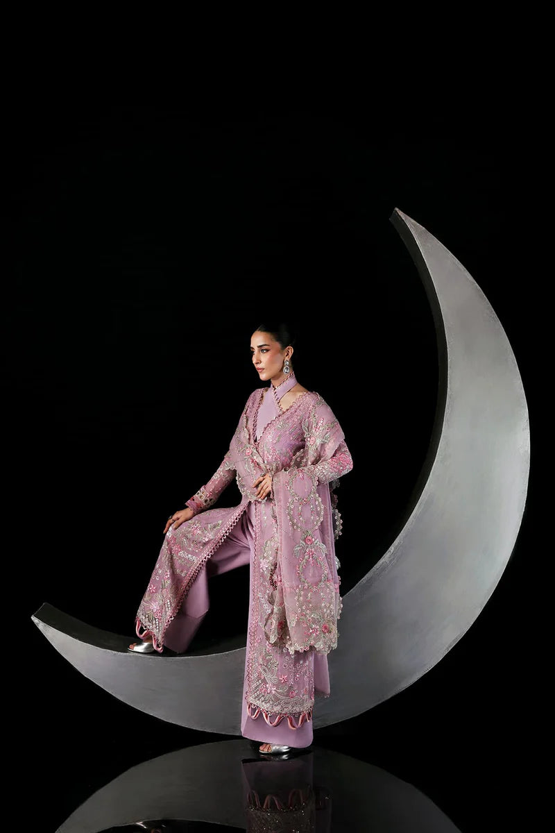 Woman in a pink traditional outfit sitting on a metallic crescent moon against a black background.
Serein By Ruuposh Collection 02
