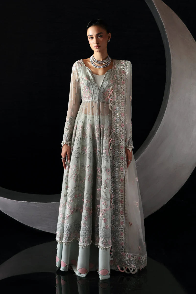 Woman wearing a long, light-colored embroidered dress against a black background.
Verae By Ruuposh Collection 01