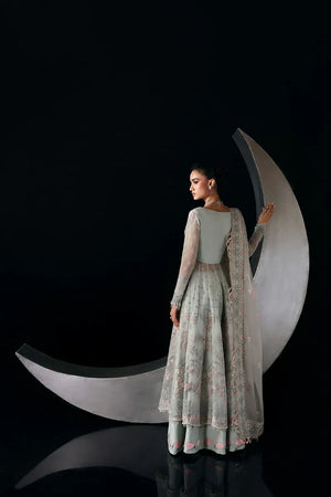 Woman in a light green traditional outfit standing against a black background with a large white crescent moon.
Verae By Ruuposh Collection 05
