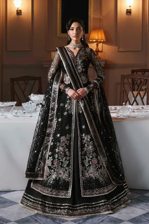 zarafreen . Woman in a black and silver embroidered traditional outfit in an elegant room.