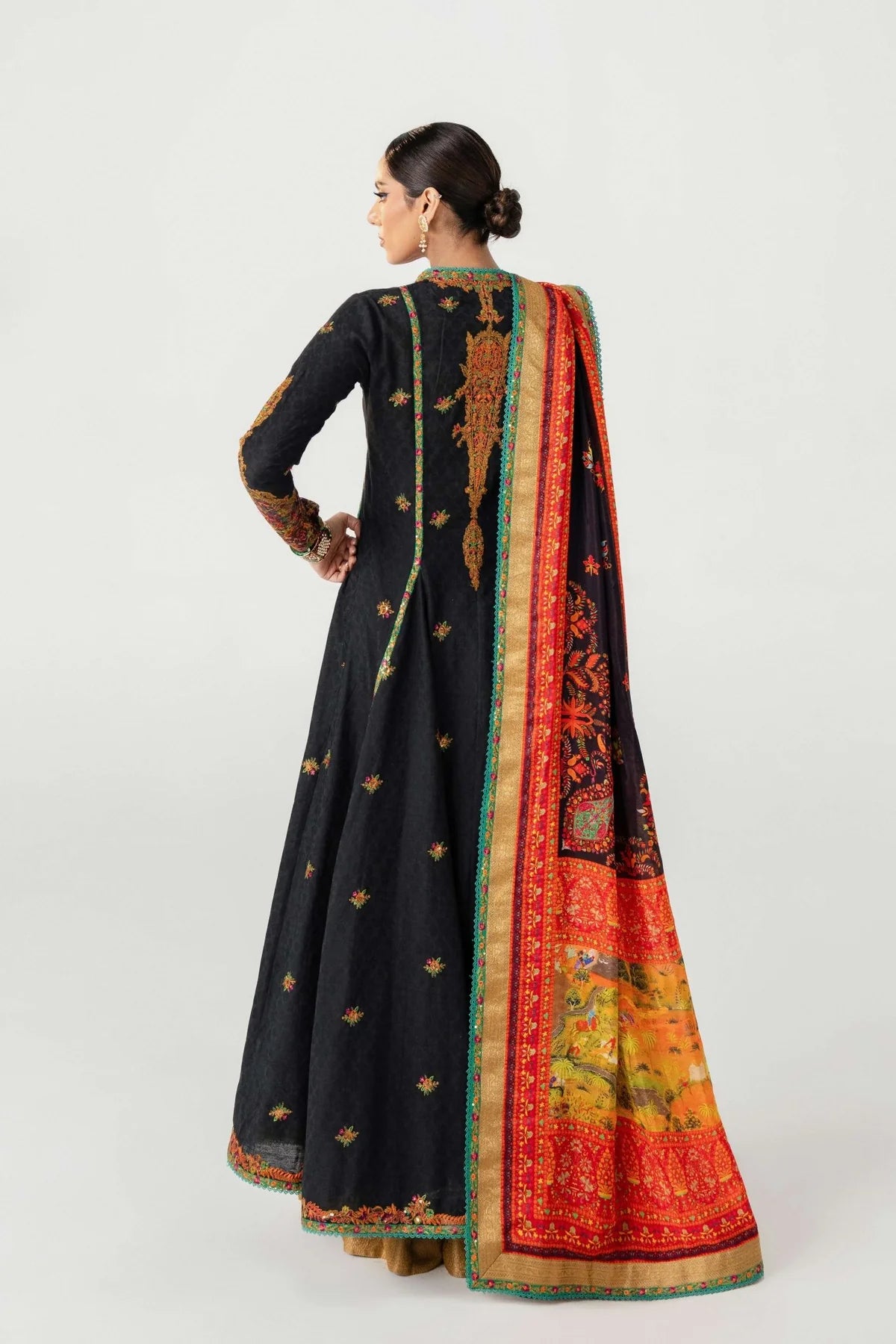 Woman wearing a black traditional outfit with a colorful dupatta on a white background
dochalla_By_Ruuposh_Collection_06
