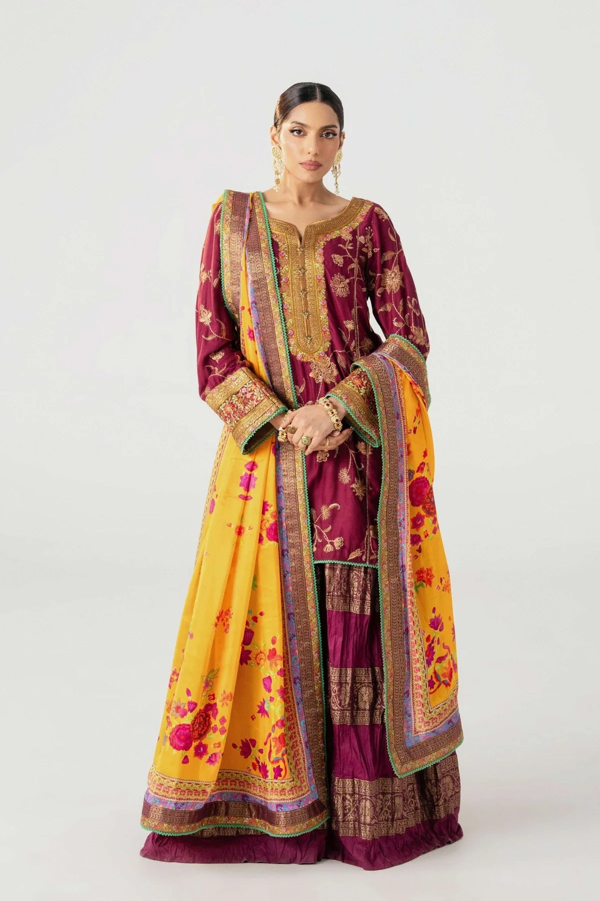 Woman wearing a traditional outfit with a yellow and maroon saree on a white background.
tojis By Ruuposh Collection 01